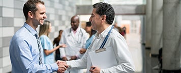 Healthcare professionals shaking hands in a hospital corridor