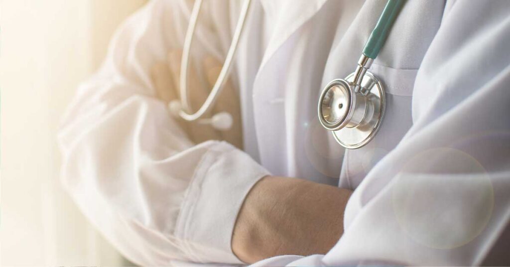Close-up of a doctor with folded arms wearing a stethoscope