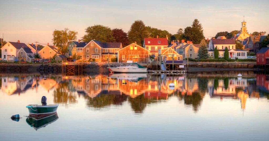 Scenic view of a waterfront village with colorful houses and boats reflected in the calm water