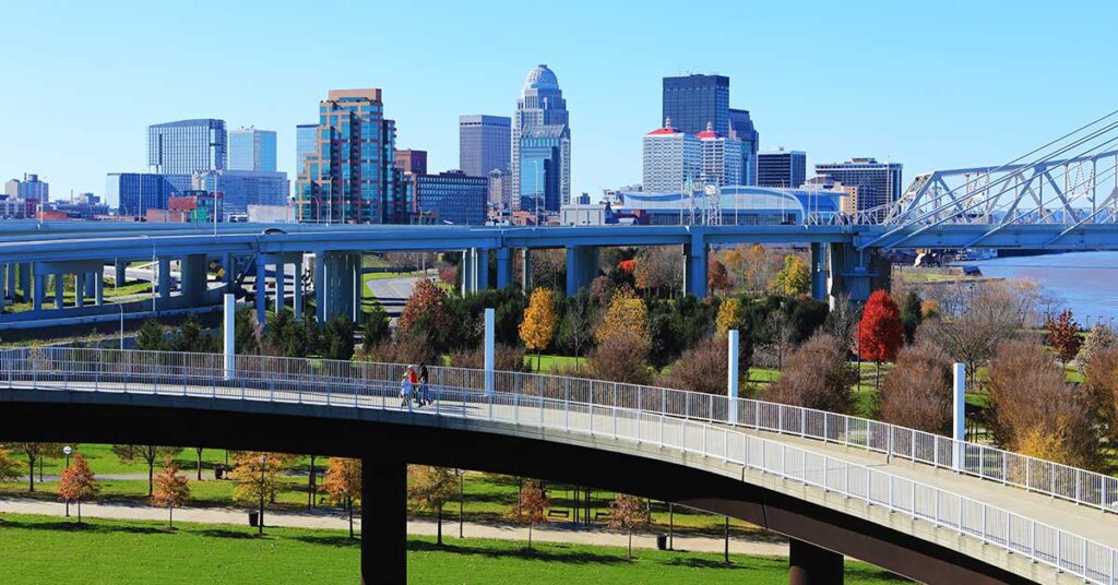 Scenic view of a city skyline with modern bridges and green parks in the foreground