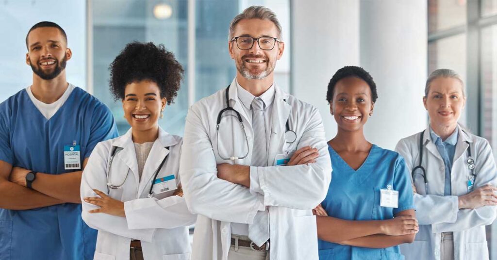 Diverse team of doctors and nurses standing confidently in a bright hospital hallway