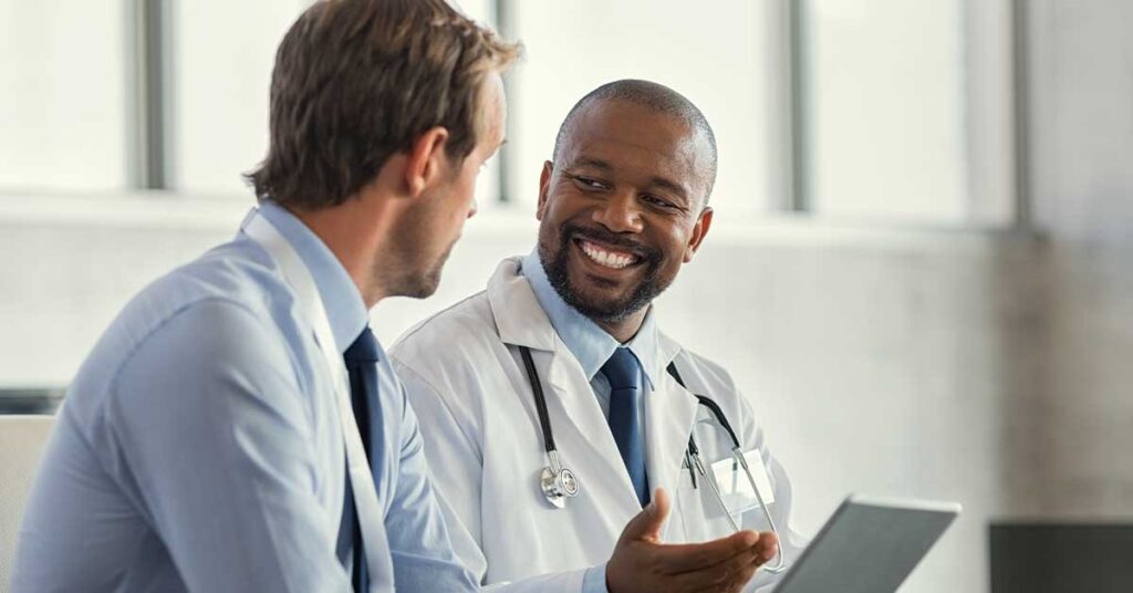 Smiling doctor having a conversation with a professional in a modern office setting