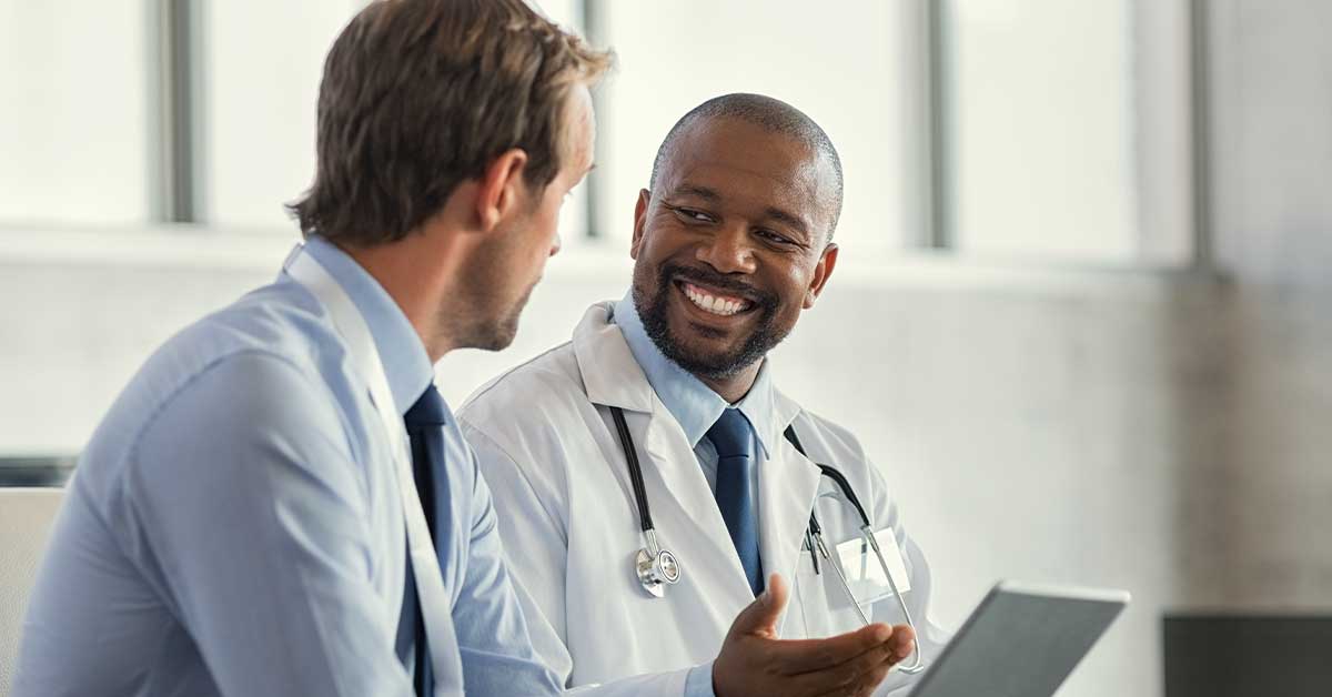 Smiling doctor having a conversation with a professional in a modern office setting