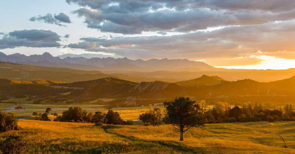 Golden western Colorado sunset with mountains and trees