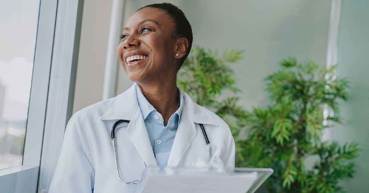 Happy female doctor looking out the window