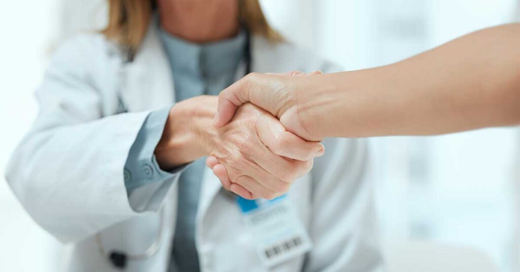 Two doctors shaking hands at a hospital