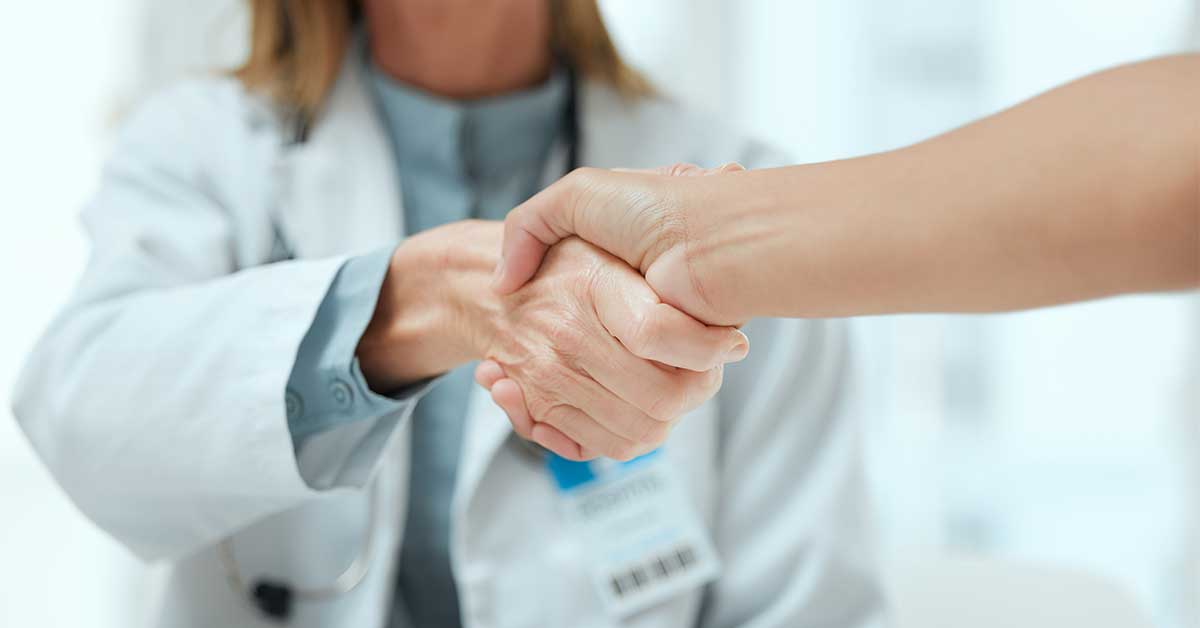 Two doctors shaking hands at a hospital