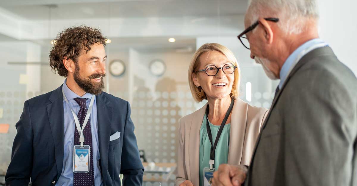 Older executive speaking with younger employee