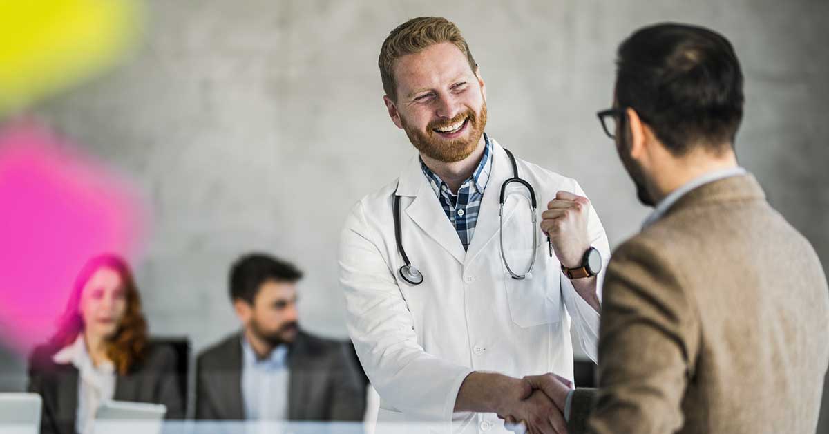 Happy doctor shaking hands with executive