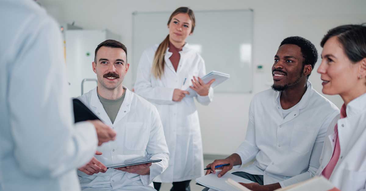 Diverse medical students learning from experienced professional in clinic