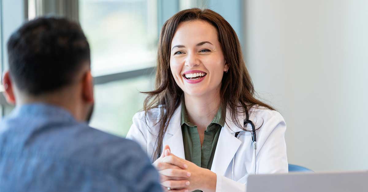 Cheerful female doctor speaking with male