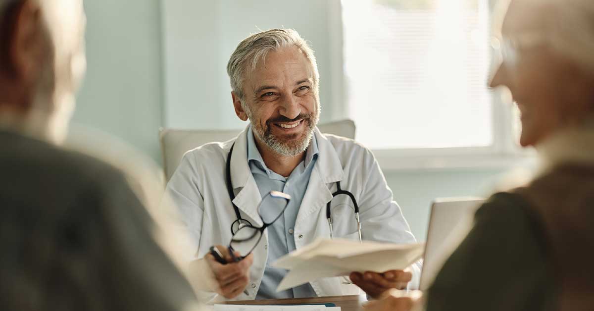 Happy male doctor having an appointment in the office.