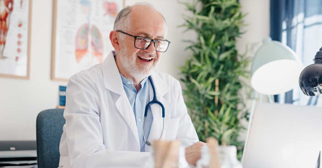 Close up of a mature male doctor using telehealth services to provide virtual care