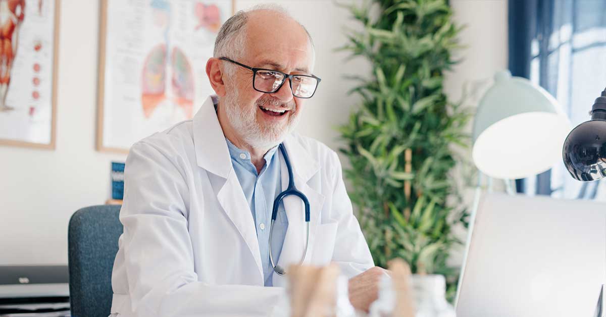Close up of a mature male doctor using telehealth services to provide virtual care