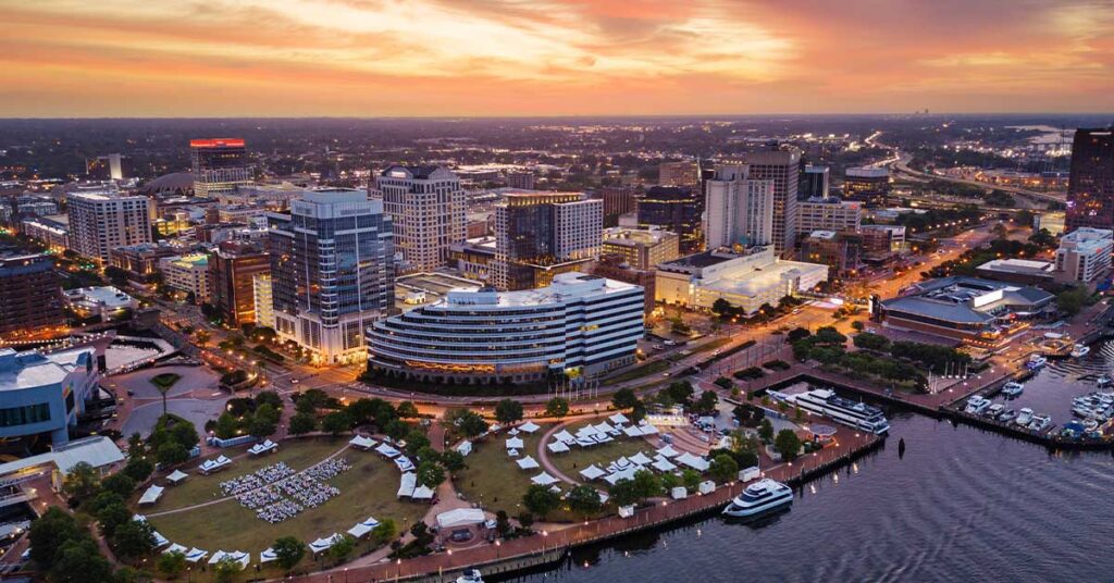 Norfolk, Virginia, USA downtown city skyline from over the Elizabeth River at dusk.