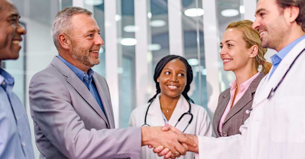 Mature businessman shaking hands with a doctor in the hospital